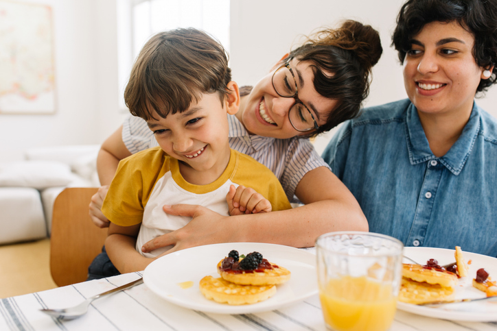 A happy family over breakfast. Diversity in foster care